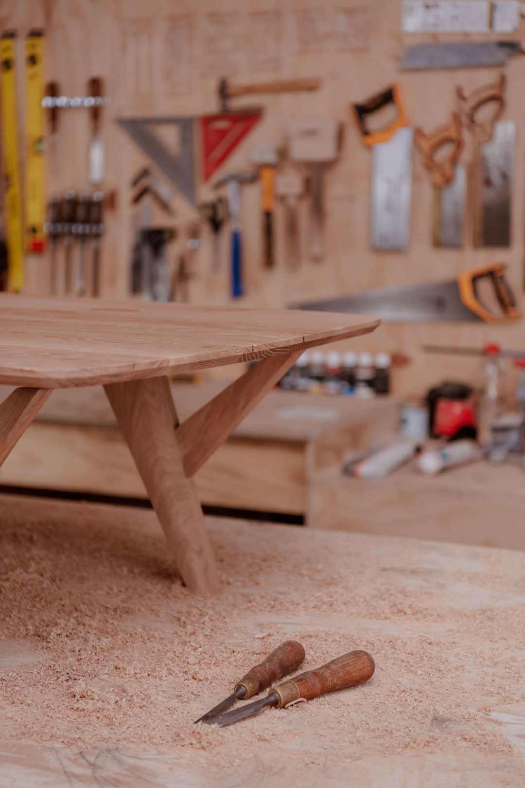 Wood coffee table inside of a woodworking shop with wood chisels in front of it. Wood table finished with Osmo Polyx®-Oil 3044 Raw